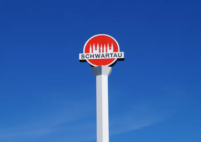 Werbeturm der Schwartauer Werke mit Schwartau Logo und blauem Himmel 